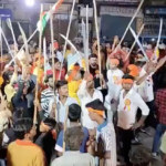 Shobha Yatra participants flash swords while marching through Dhanbad